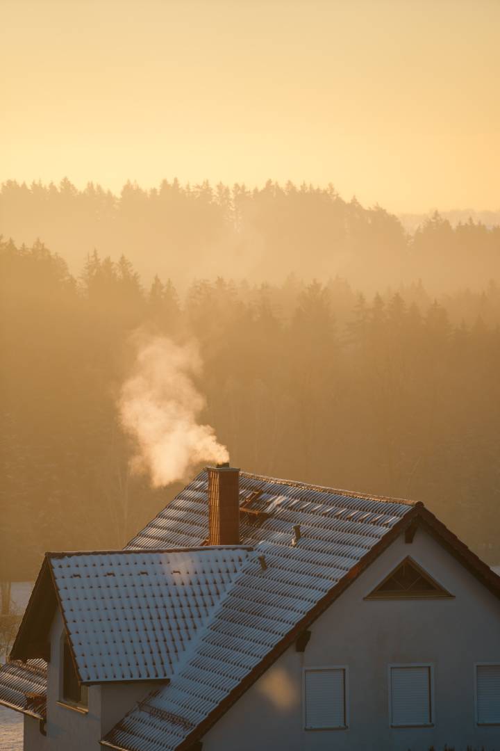 House In Winter With Smoke Coming Out the Chimney